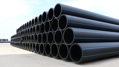 Large stack of black HDPE pipes with blue stripes stored outdoors at an industrial facility for LNG/LPG applications.